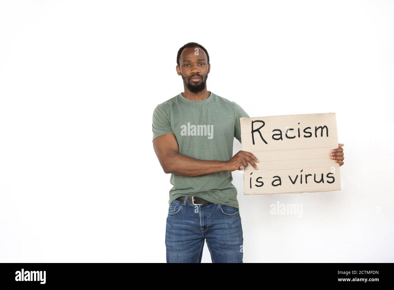 Racism is a virus. Young man protesting with sign isolated on white studio background. Activism, active social position, protest, actual problems. Meeting against human rights, abusing, racism. Stock Photo