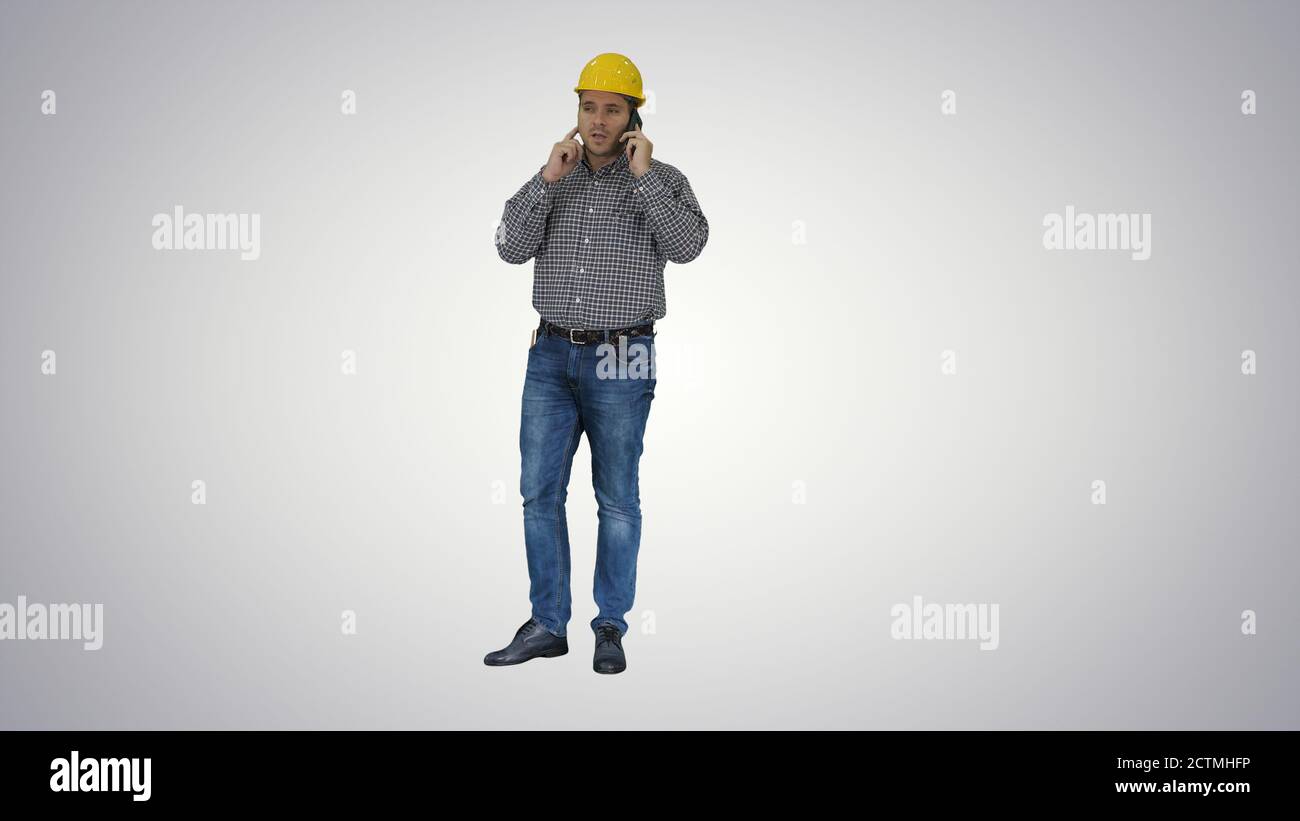 Construction worker using smartphone on gradient background. Stock Photo