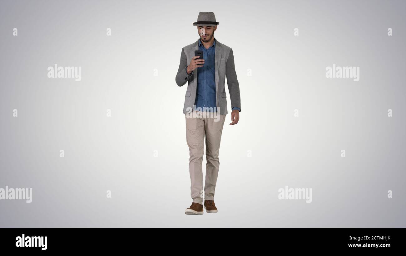 Smart casual arabian man using smartphone while walking on gradi Stock Photo