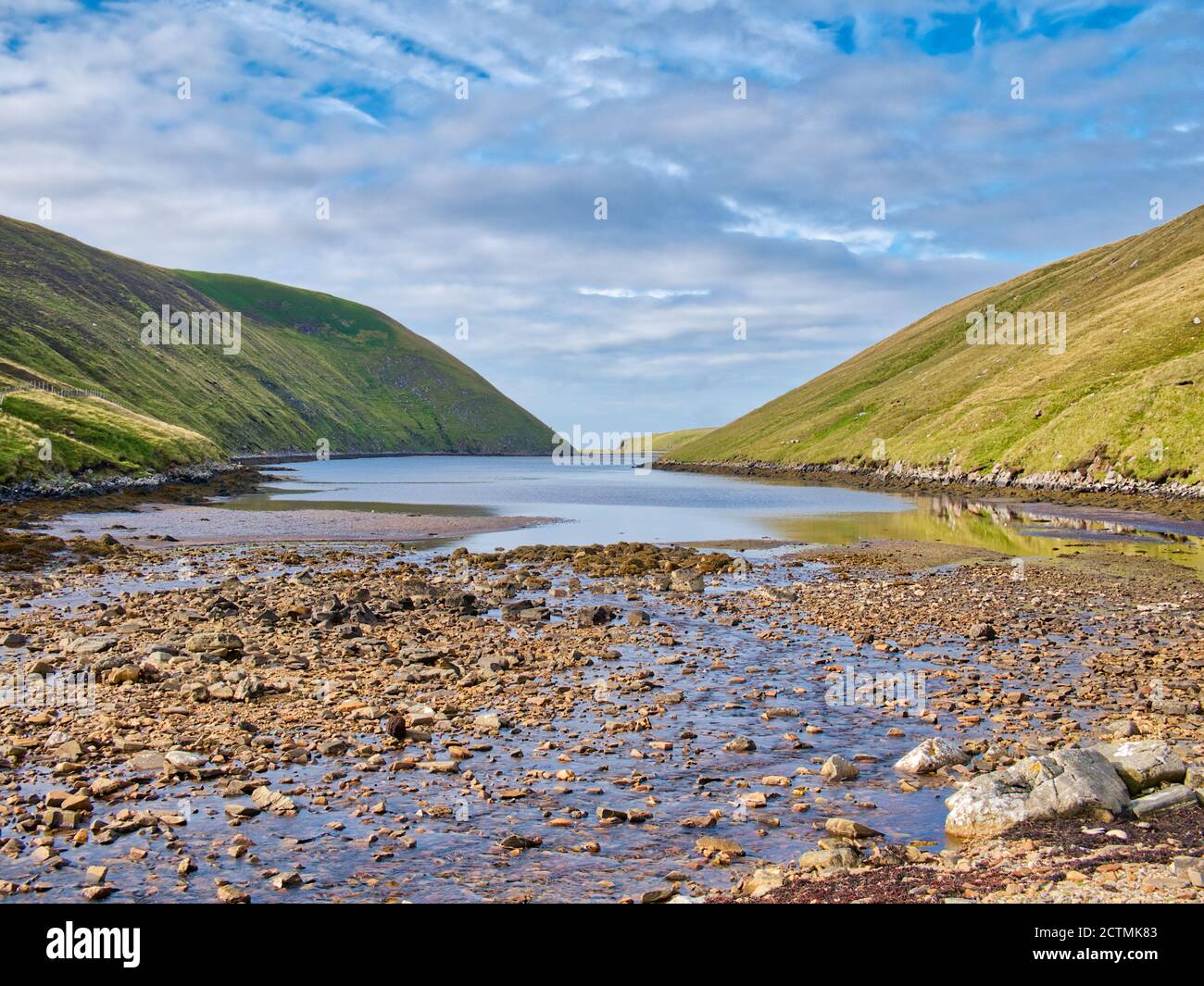 Sunshine on Mare's Pool and the Wester and Easter Lee of Gloup at low tide at the south end of Gloup Voe on the north of the island of Yell in Shetlan Stock Photo