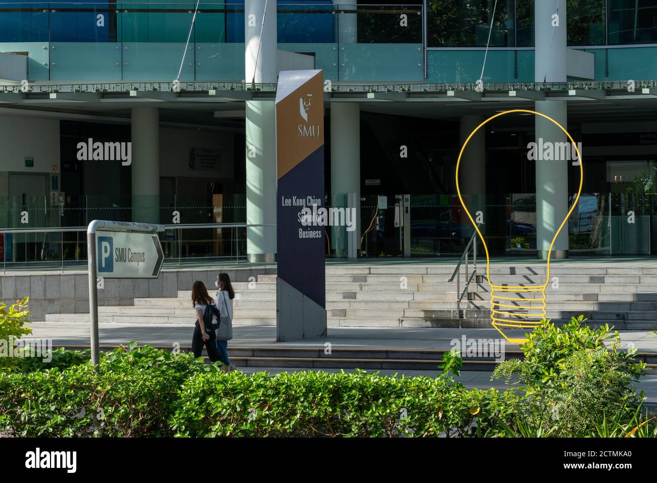 SINGAPORE, SINGAPORE - Sep 10, 2020: Two young women walk pass the Singapore Management University , sign of Lee Kong Chian School of Business Stock Photo