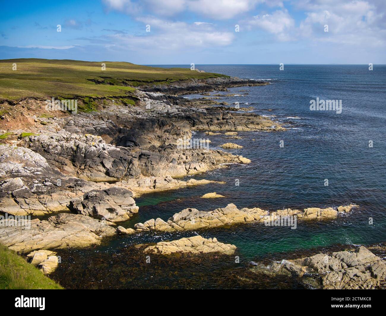 Dramatic coastal scenery showing inclined and eroded rock strata around the Ness of Queyon, near Otters Wick on the island of Yell in Shetland, UK Stock Photo