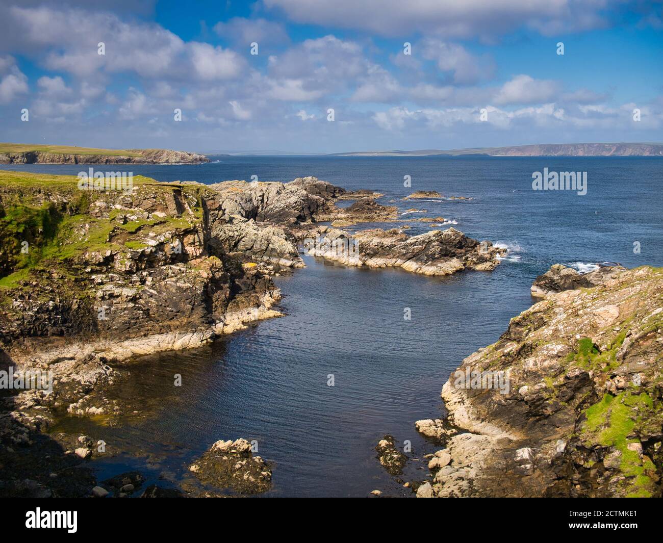 Dramatic coastal scenery showing inclined and eroded rock strata around the Ness of Queyon, near Otters Wick on the island of Yell in Shetland,UK Stock Photo