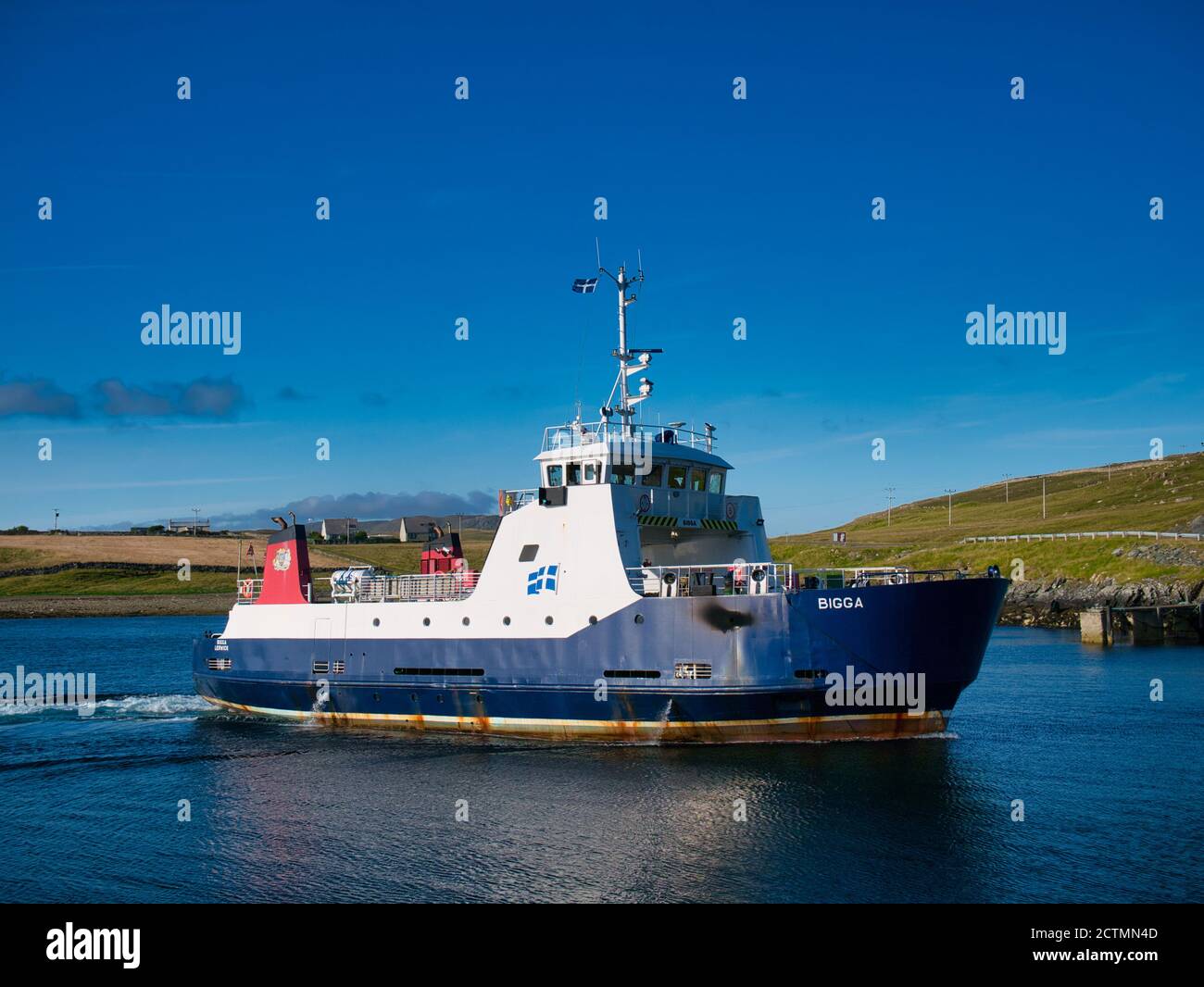 In sunshine, the interisland car ferry MV Bigga on Bluemull Sound between Yell and Unst, in Shetland, UK Stock Photo