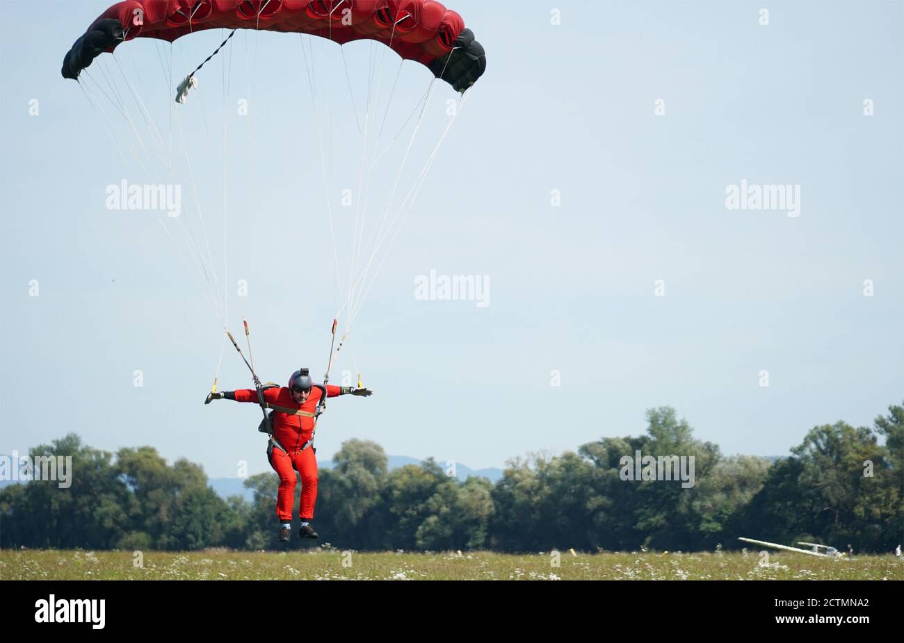 A skilled parachutist at the moment of landing colourful shot in Slavnica, Slovakia on Sept., 19th, 2020. Stock Photo