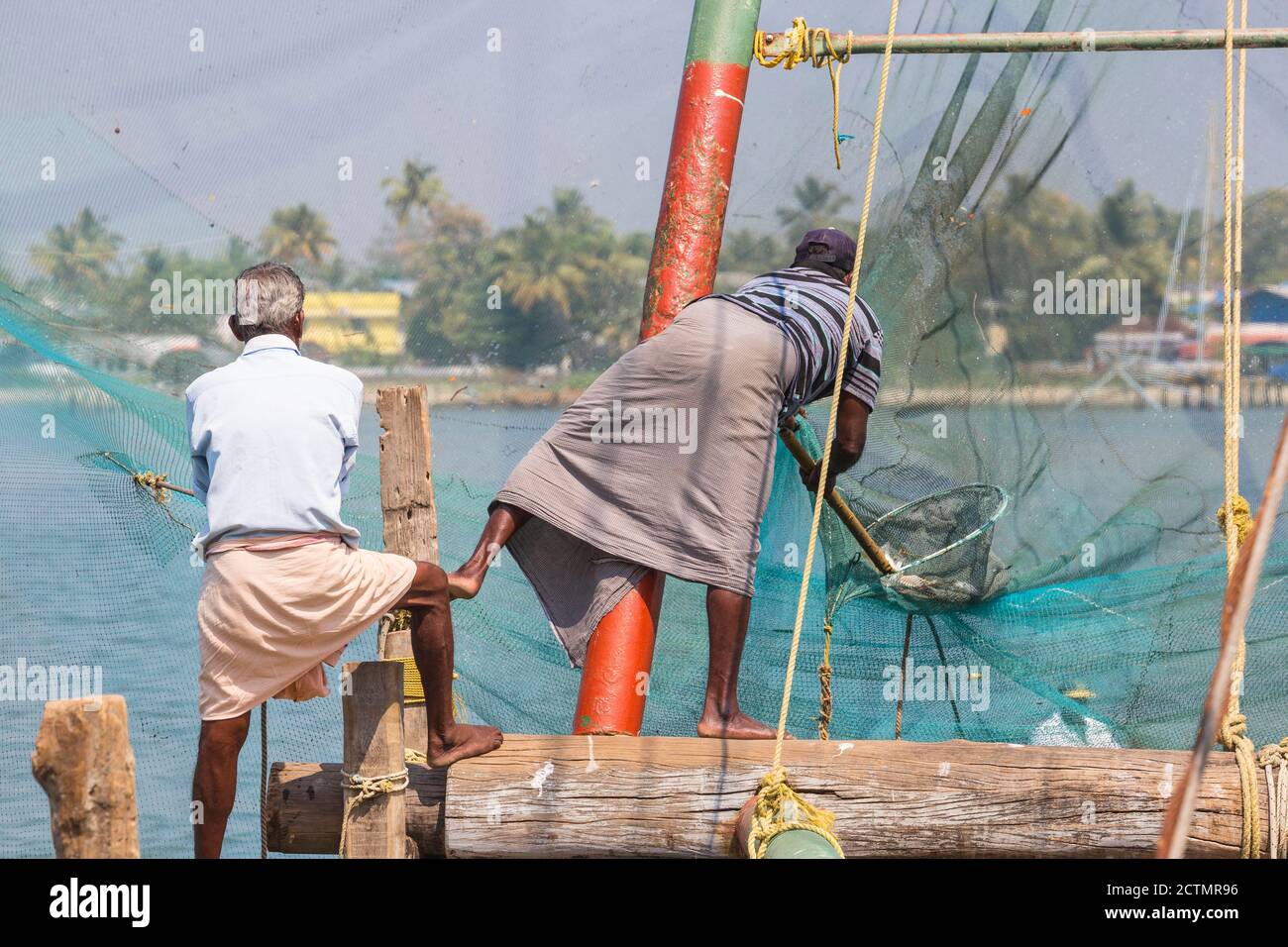 Chinese Fishing Net - This rustic rope and wooden structure stands tall .  Fishermen gather to one side of the net. Kochi India Stock Photo - Alamy