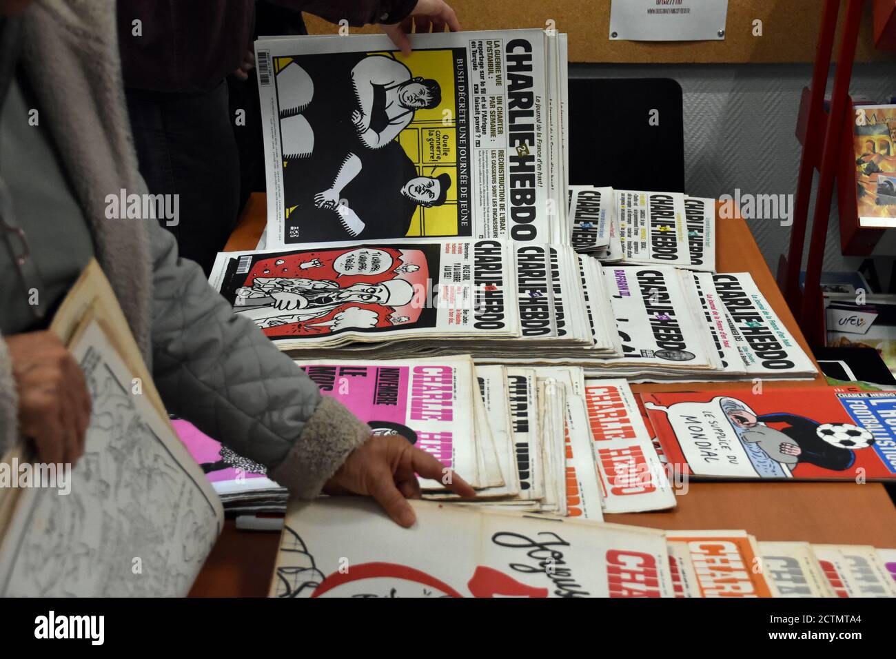 People are seen reading the old issues of the 'Charlie-Hebdo' newspapers displayed on a desk.Nearly a hundred media, newspapers, magazines, television channels and radio stations, call on the French to mobilize in favor of freedom of expression, in support of Charlie Hebdo, which has been the subject of new threats since the republication of Muhammad caricatures. The ongoing trial of the attack on the newspaper, which killed 12 on January 7, 2015, will be held until November 10, 2020. Stock Photo