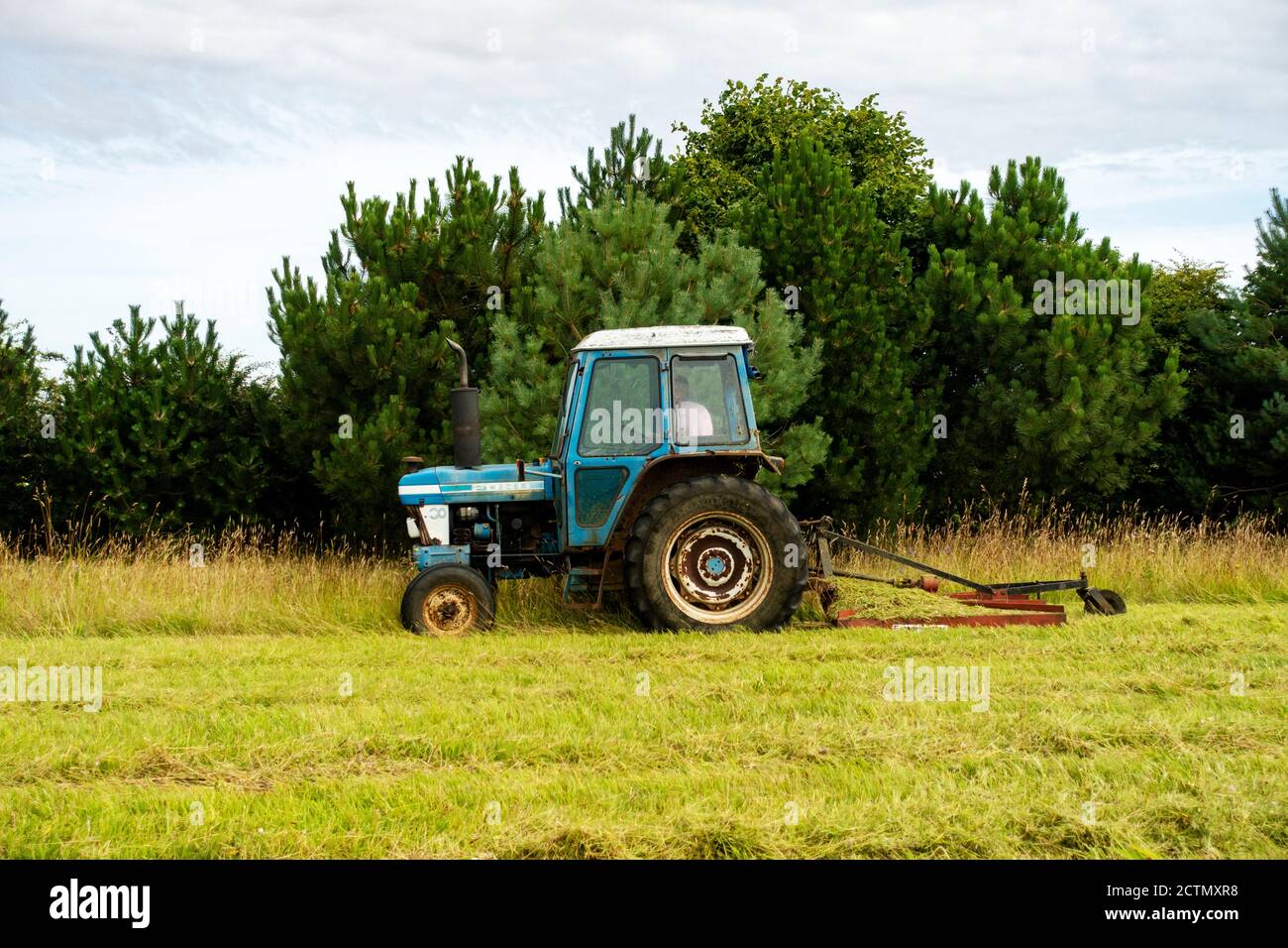 Ford tractor with grass topper Stock Photo