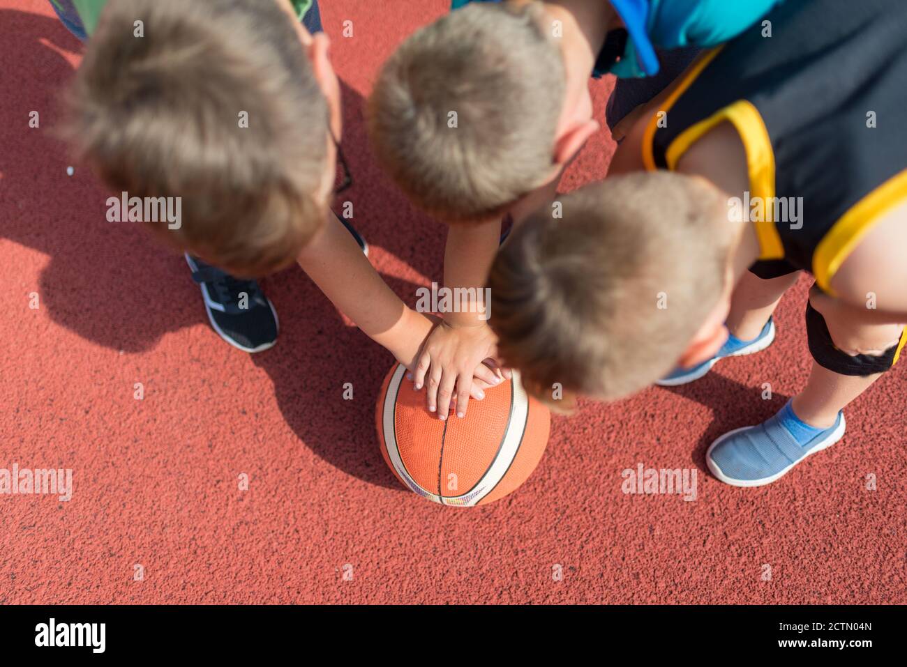 Top view Kids Basketball Team. Young Basketball Players touch Balls on Basketball Court