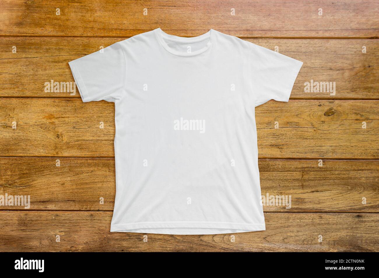 White t-shirt mockup on wood background template. Stock Photo