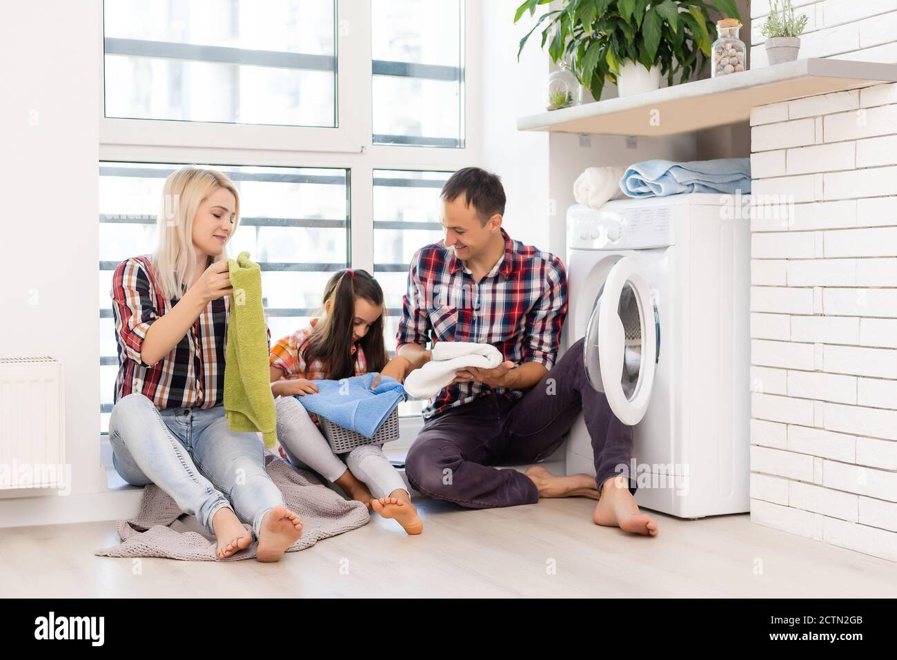 the image of a happy family doing laundry Stock Photo Alamy