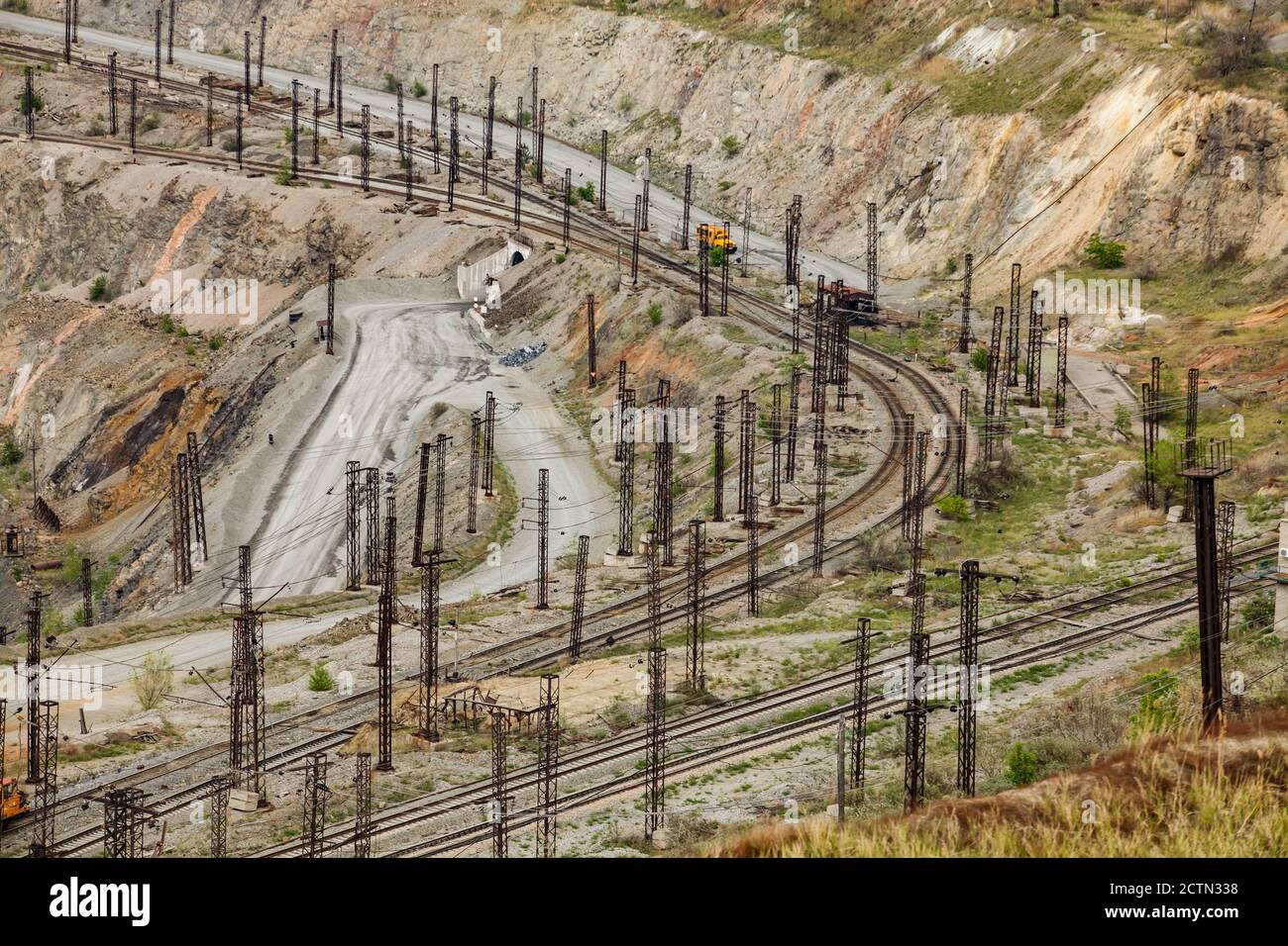 Giant iron ore quarry in Rudny, Kazakhstan.  Mining raw minerals for steel production. Railroad down the quarry. Stock Photo