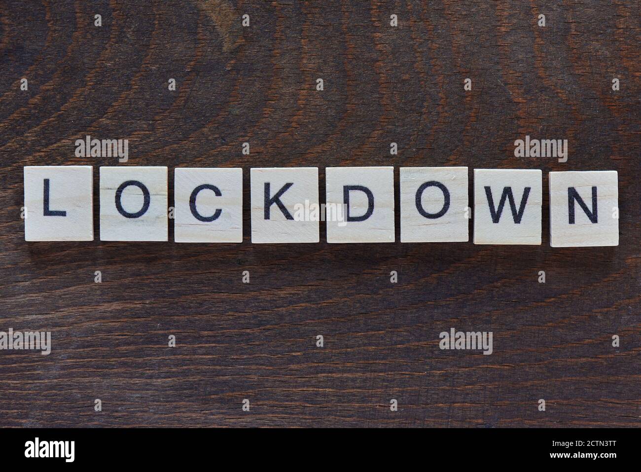 written "LOCKDOWN" with light wood letters on dark wood Stock Photo