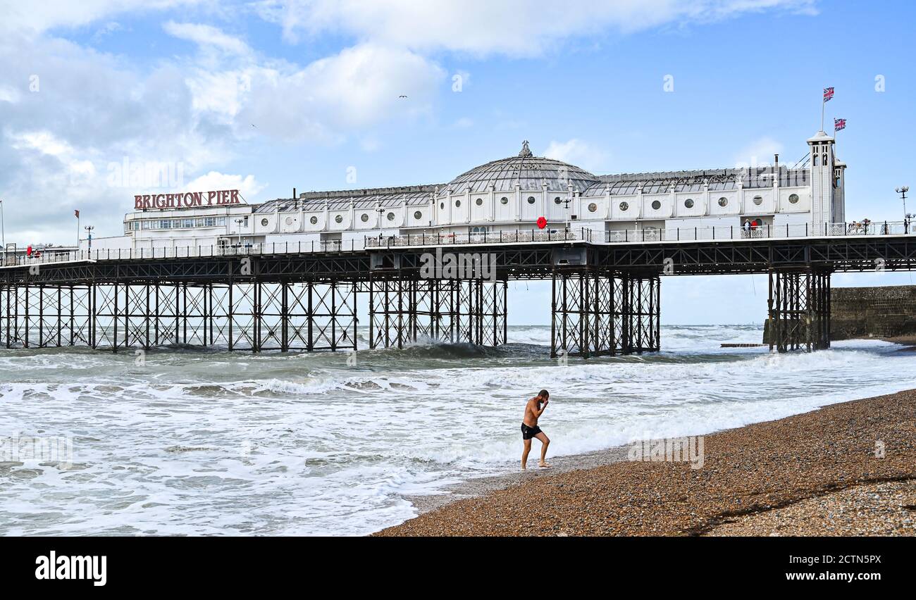 Brighton UK 24th September 2020 - A swimmer braves the sea on a windy day in Brighton with more unsettled weather forecast for Britain over the next few days : Credit Simon Dack / Alamy Live News Stock Photo