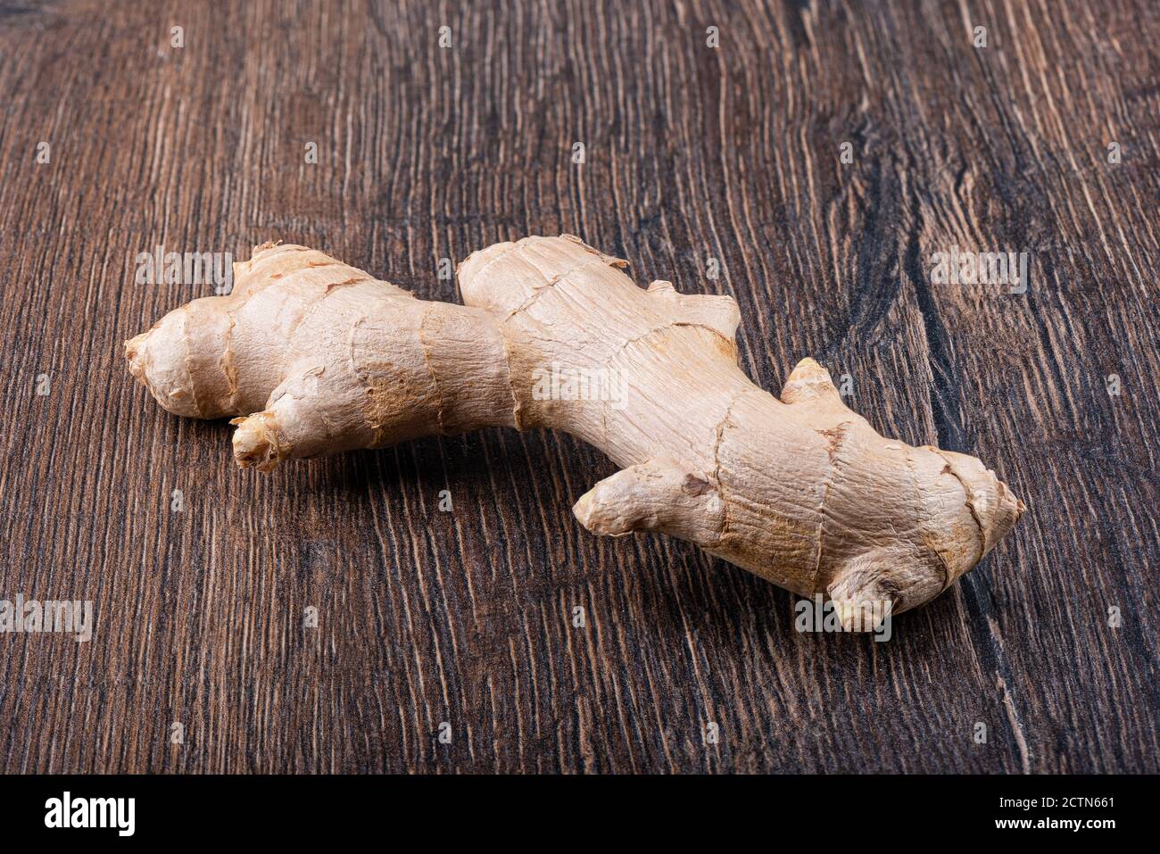 Fresh ginger root on a wooden surface. Close up. Copy space. Stock Photo