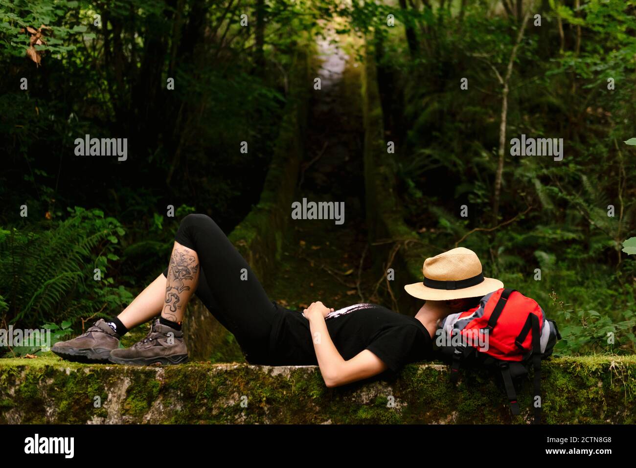 Side view of unrecognizable female explorer lying on backpack in dark woods and sleeping while resting during trekking Photo - Alamy
