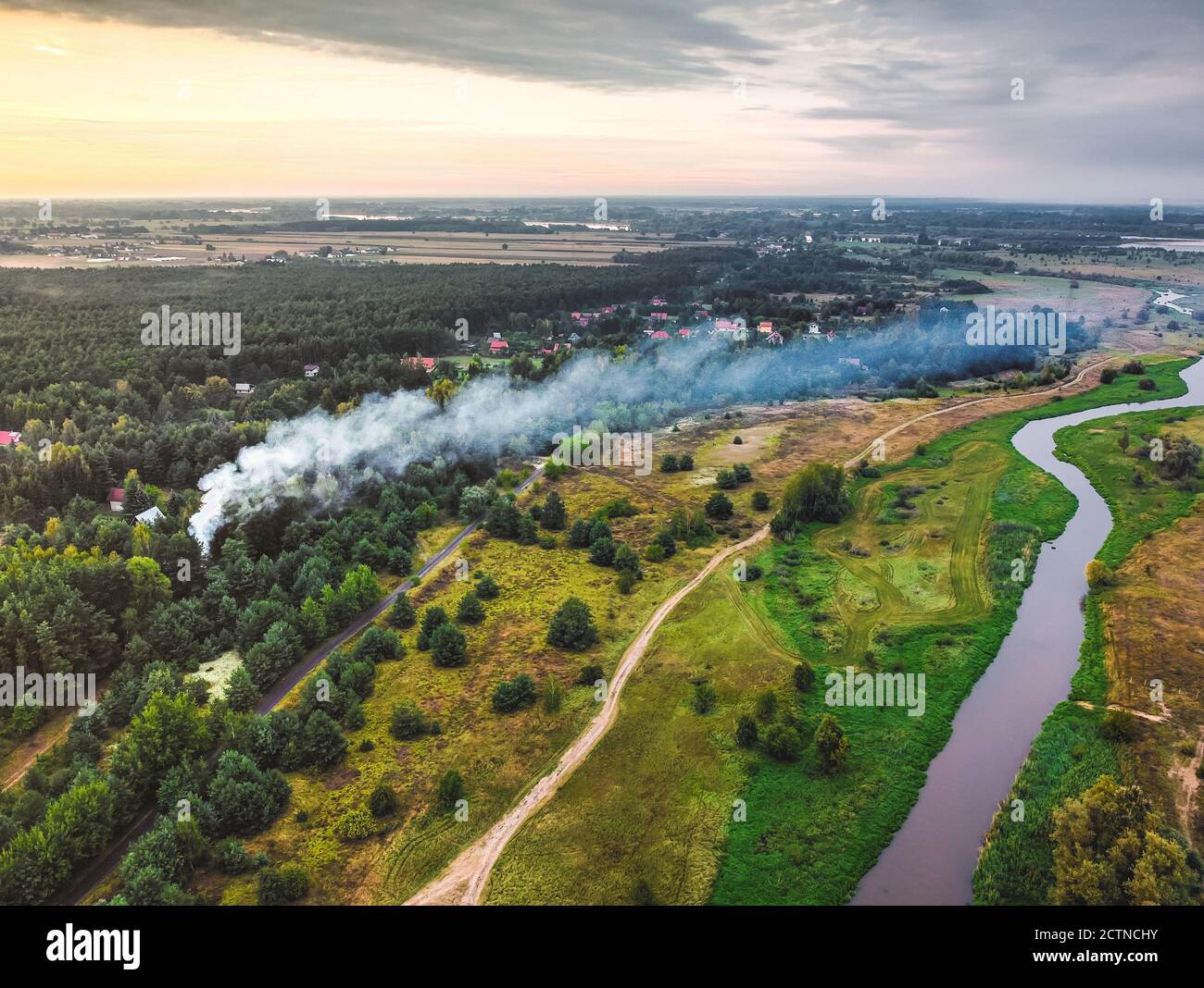 Smoke from the fire over cottages in the forest. Drone, aerial View. Stock Photo