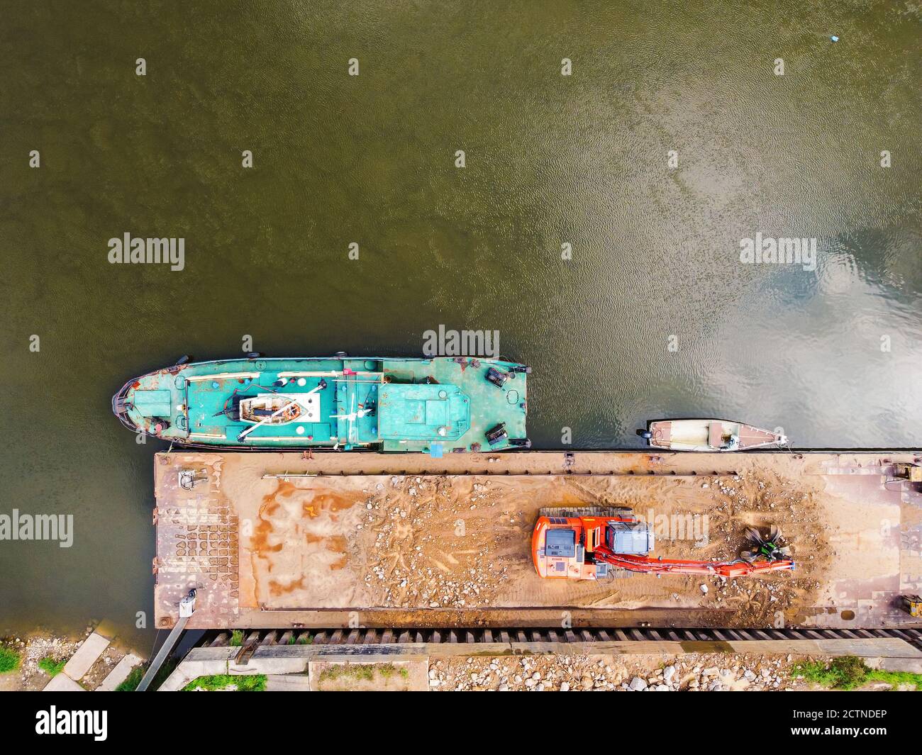 Old military boat stranded and left to rust on the bank of a river. Drone, aerial view Stock Photo
