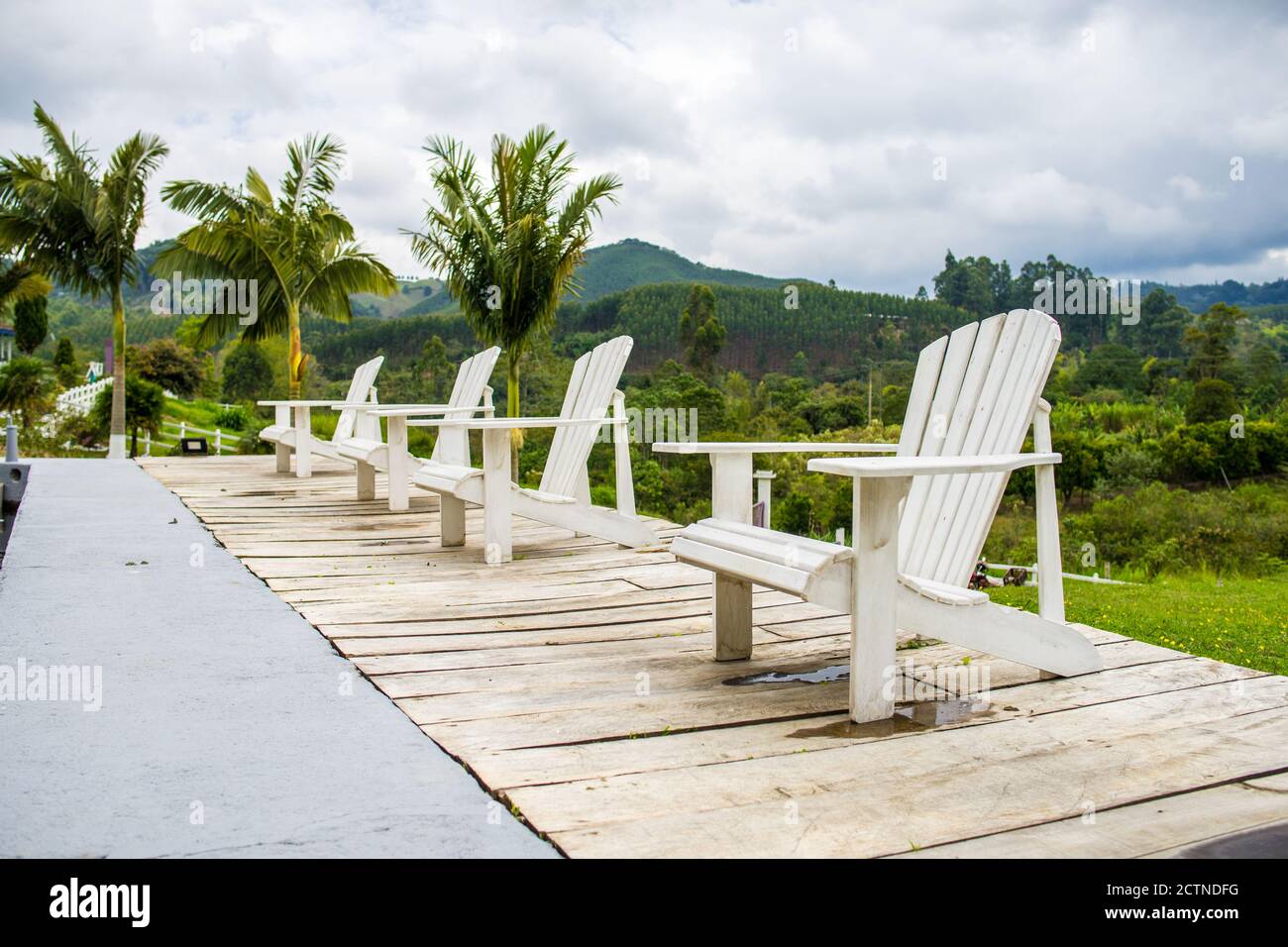 Collection of wooden deck chairs at poolside of resort on background of ...