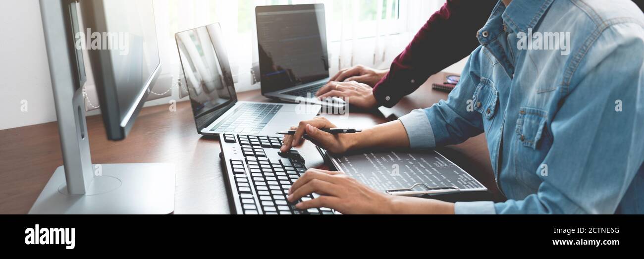 Team of Programmer working to find solution to problem and coding technologies in a software developing company office Stock Photo
