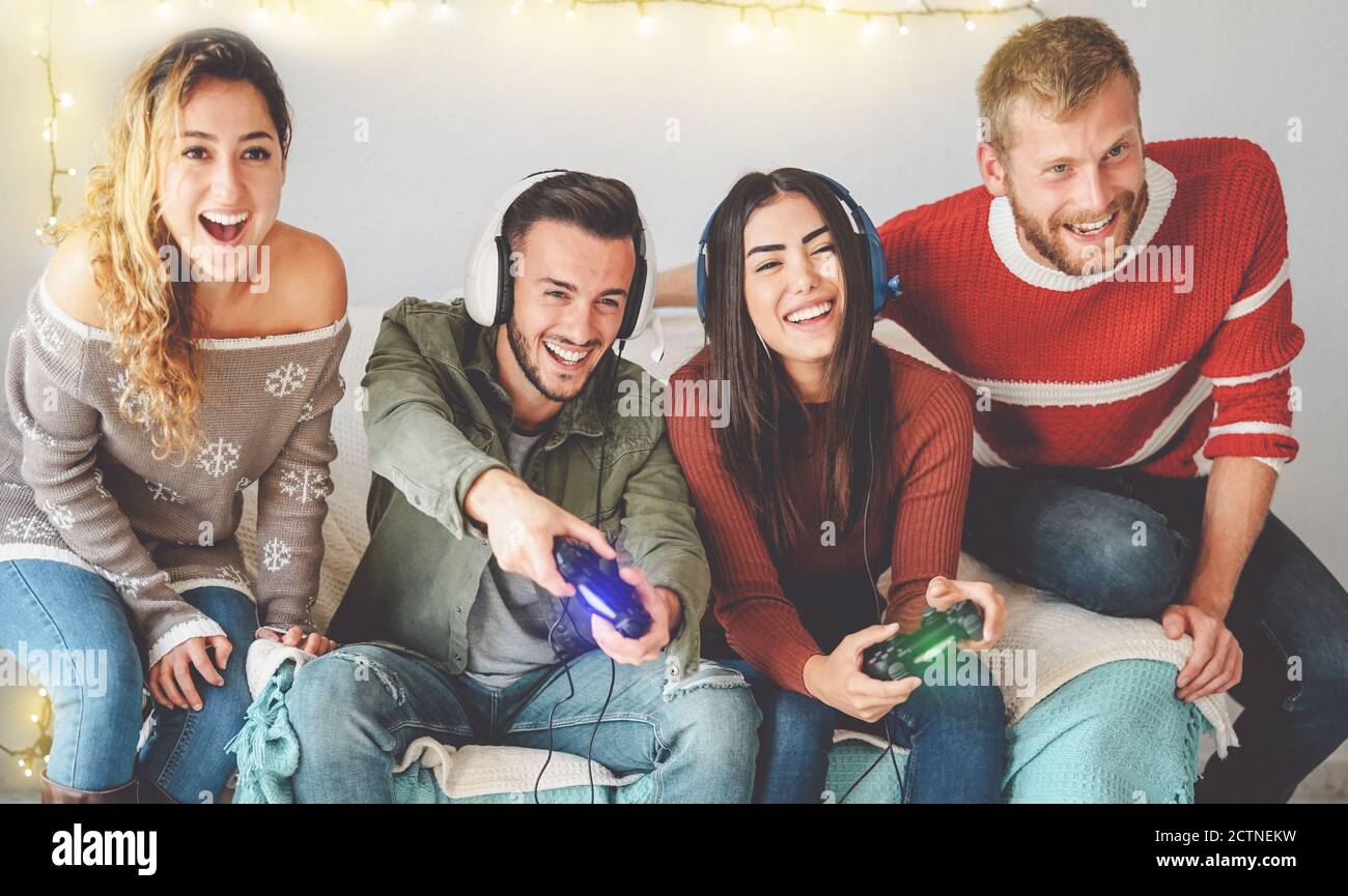 Happy friends playing video games online with headset - Young ...