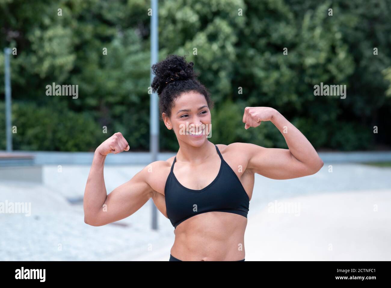 Delighted African American athletic female with strong arms