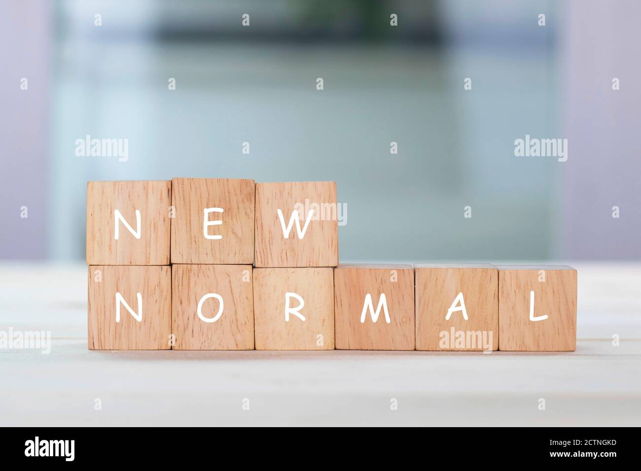 New normal on wooden cube with blurred background. Stock Photo