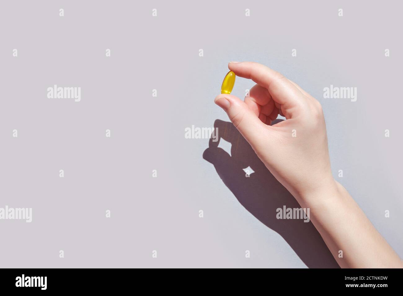 Omega3 gel capsule. Yellow vitamin. Yand holding drug Stock Photo Alamy