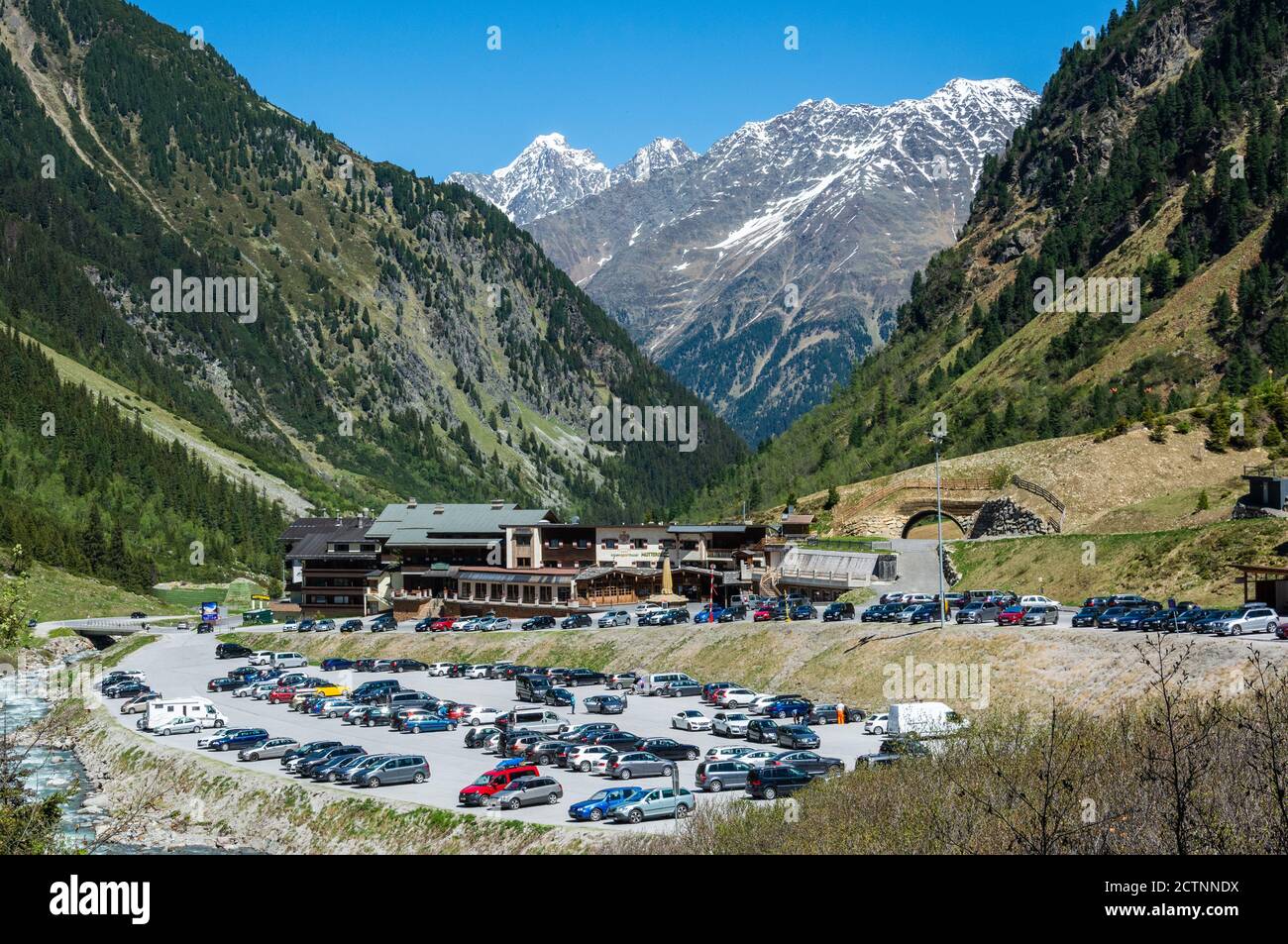 Neustift im Stubaital, Austria – May 27, 2017. View over Alpensporthotel Mutterberg and parking ground of Stubai cable cars, with people, commercial p Stock Photo