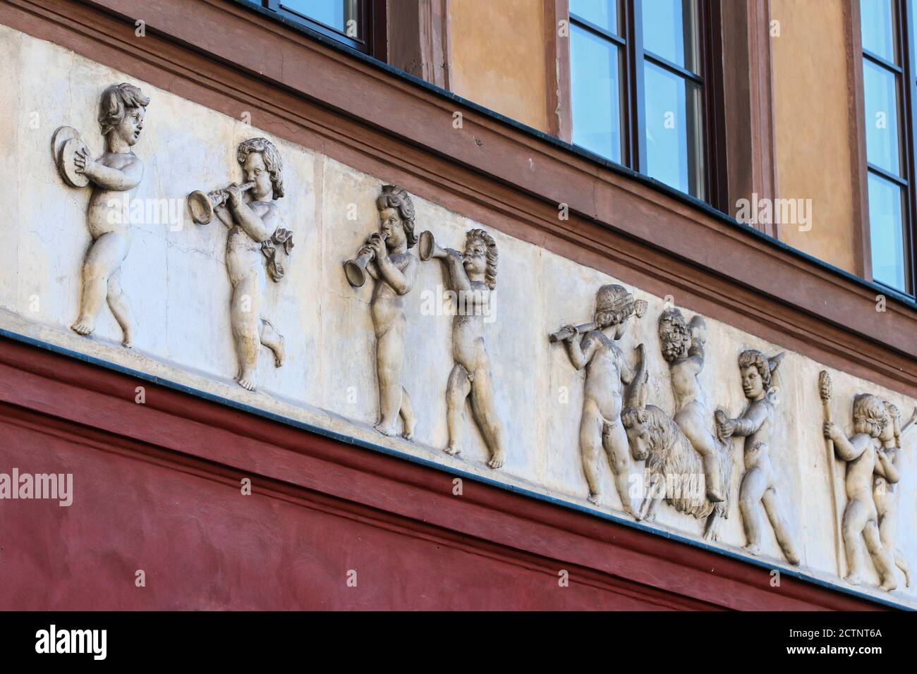 Relief depicting little boys with musical instruments and goat on front elevation of old tenement house Stock Photo