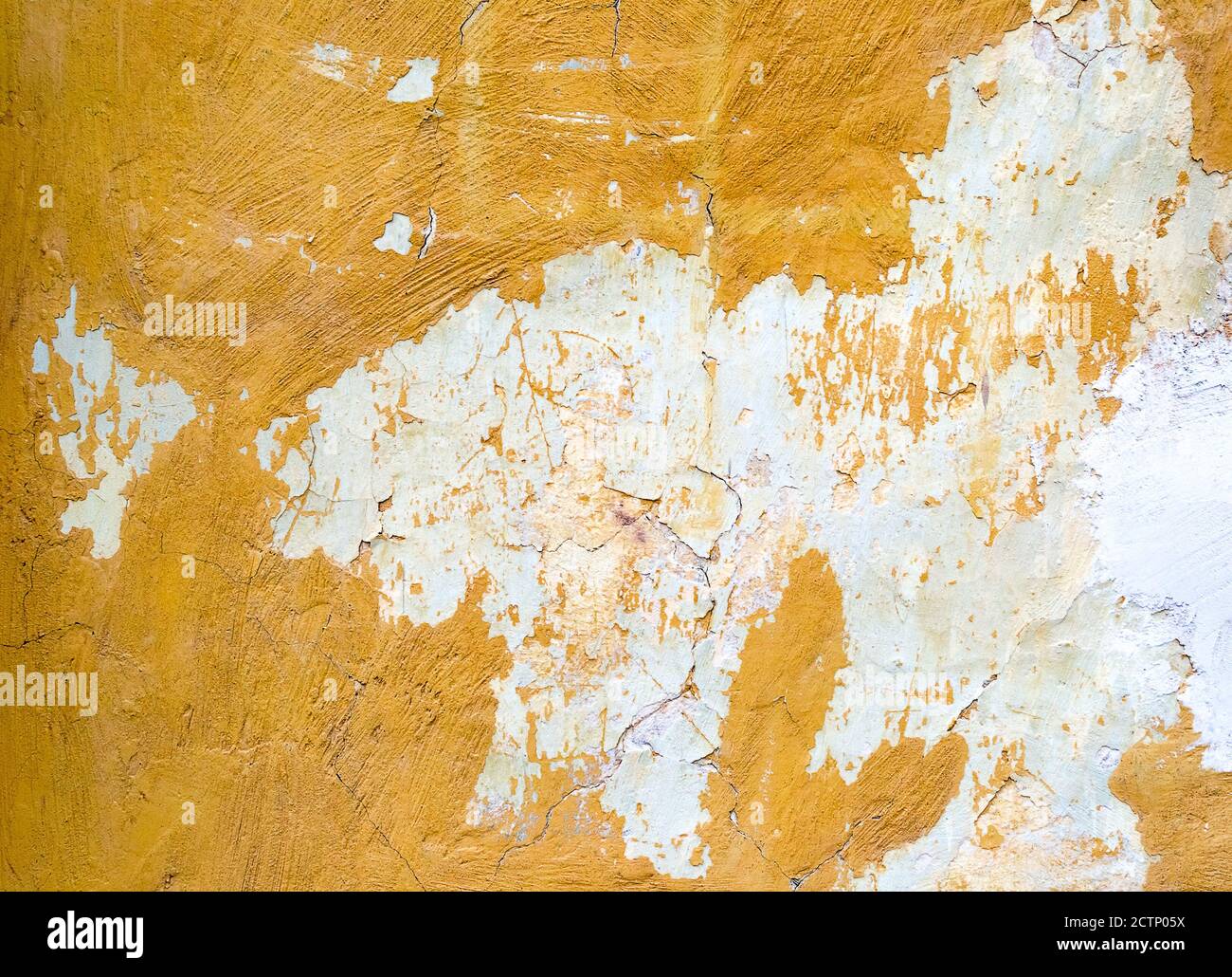 Cracked painted yellow concrete wall background or texture Stock Photo