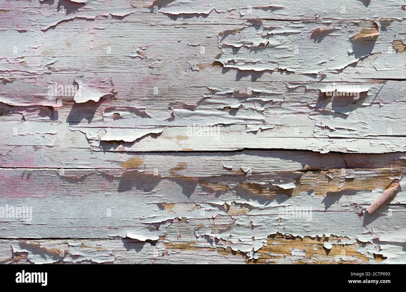 Cracked paint on a wooden wall. Wall from wooden planks with paint traces. Grunge background, cracked paint. Stock Photo