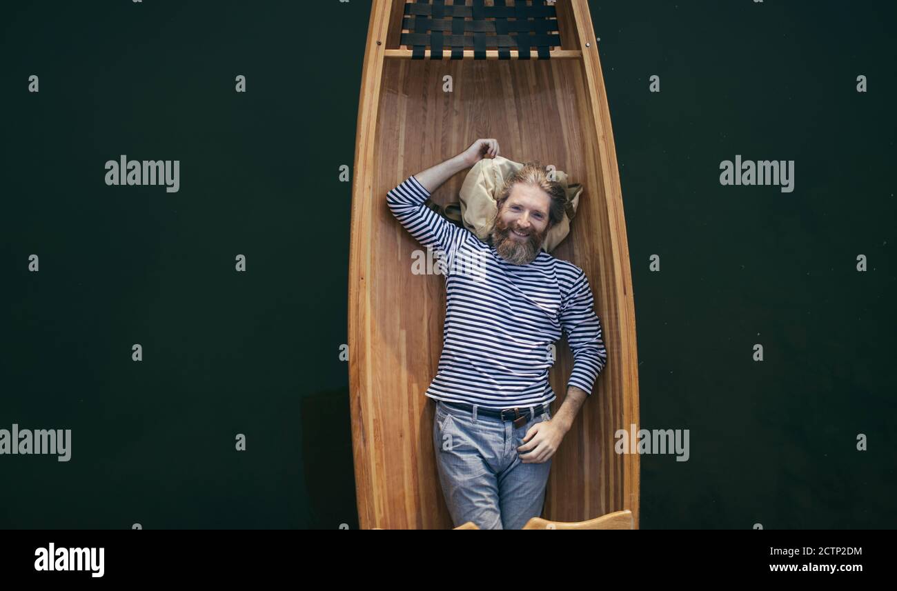 Smiling bearded man relaxing in the boat Stock Photo