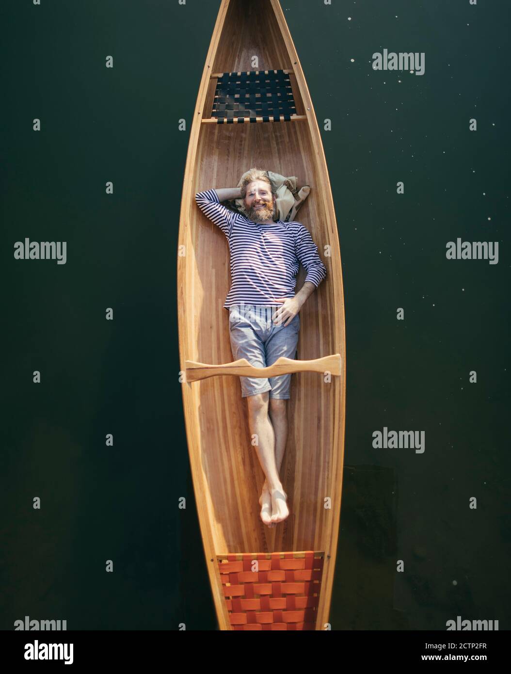 Smiling bearded man relaxing in the boat Stock Photo