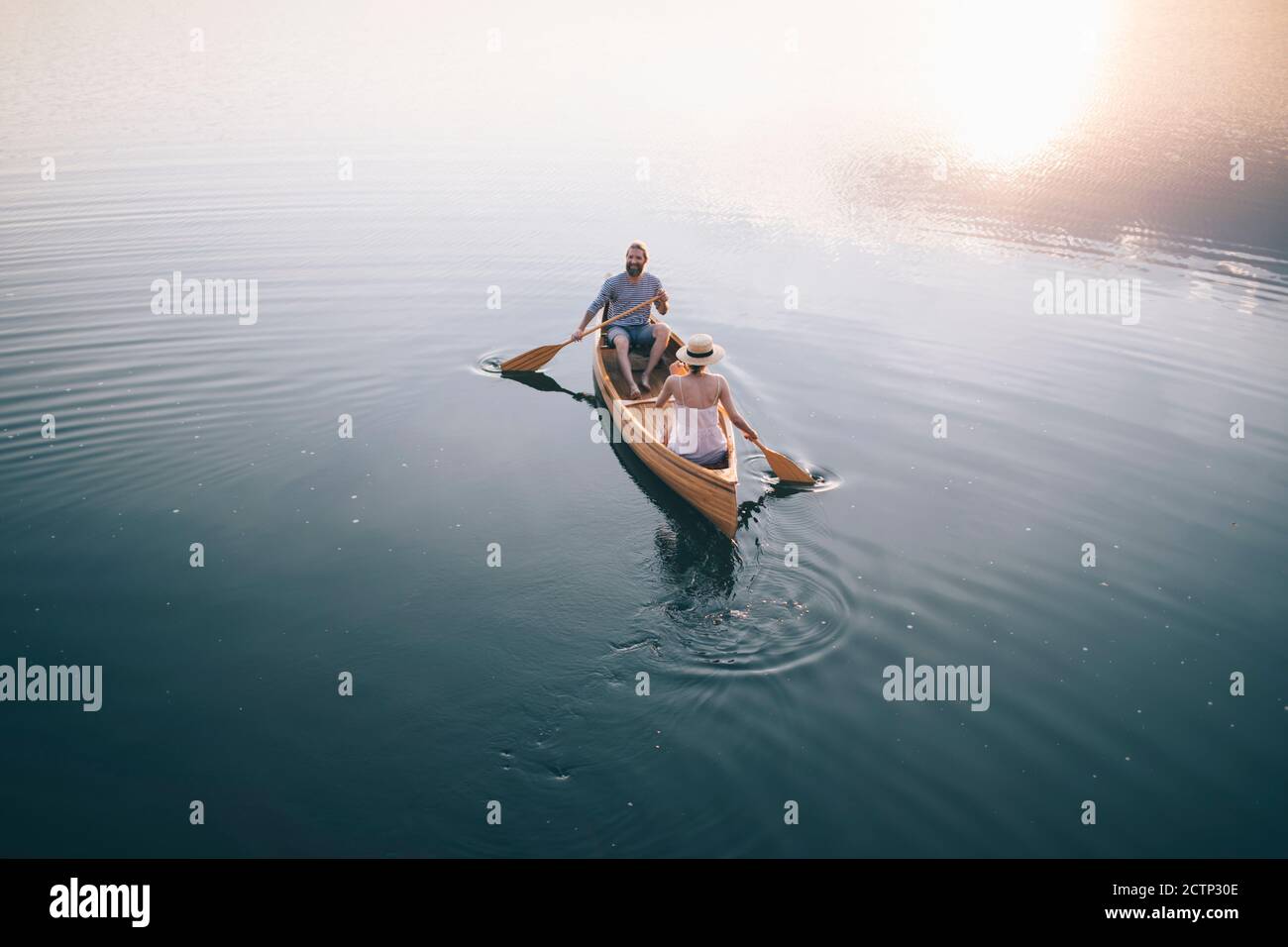 Romantic couple paddling canoe Stock Photo - Alamy