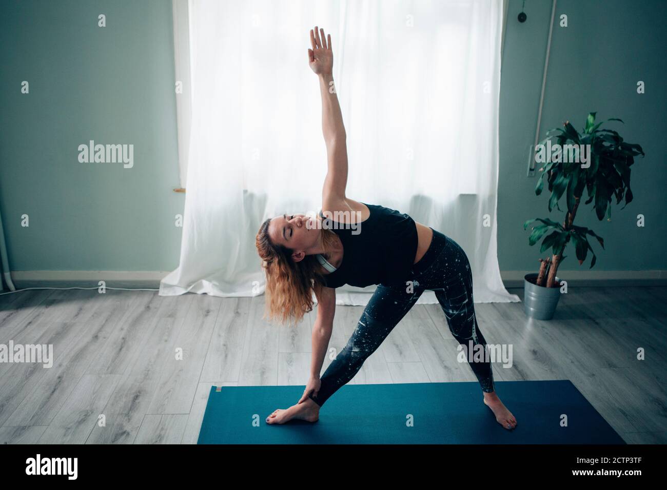 young yoga teacher doing positions at the yoga school Stock Photo