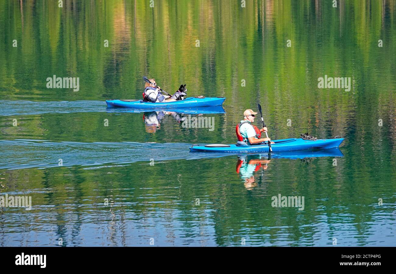 Two kayakeres glide over the green deep water of Suttle Lake in the Cascade Mountains near Sisters, Oregon. Stock Photo