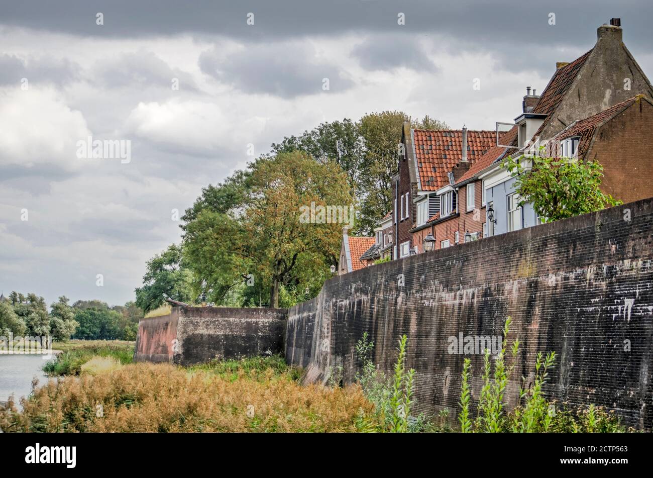 Woudrichem, The Netherlands, September 23, 2020: houses built on the town's wall, overlooking the surrounding nature and the river Waal Stock Photo