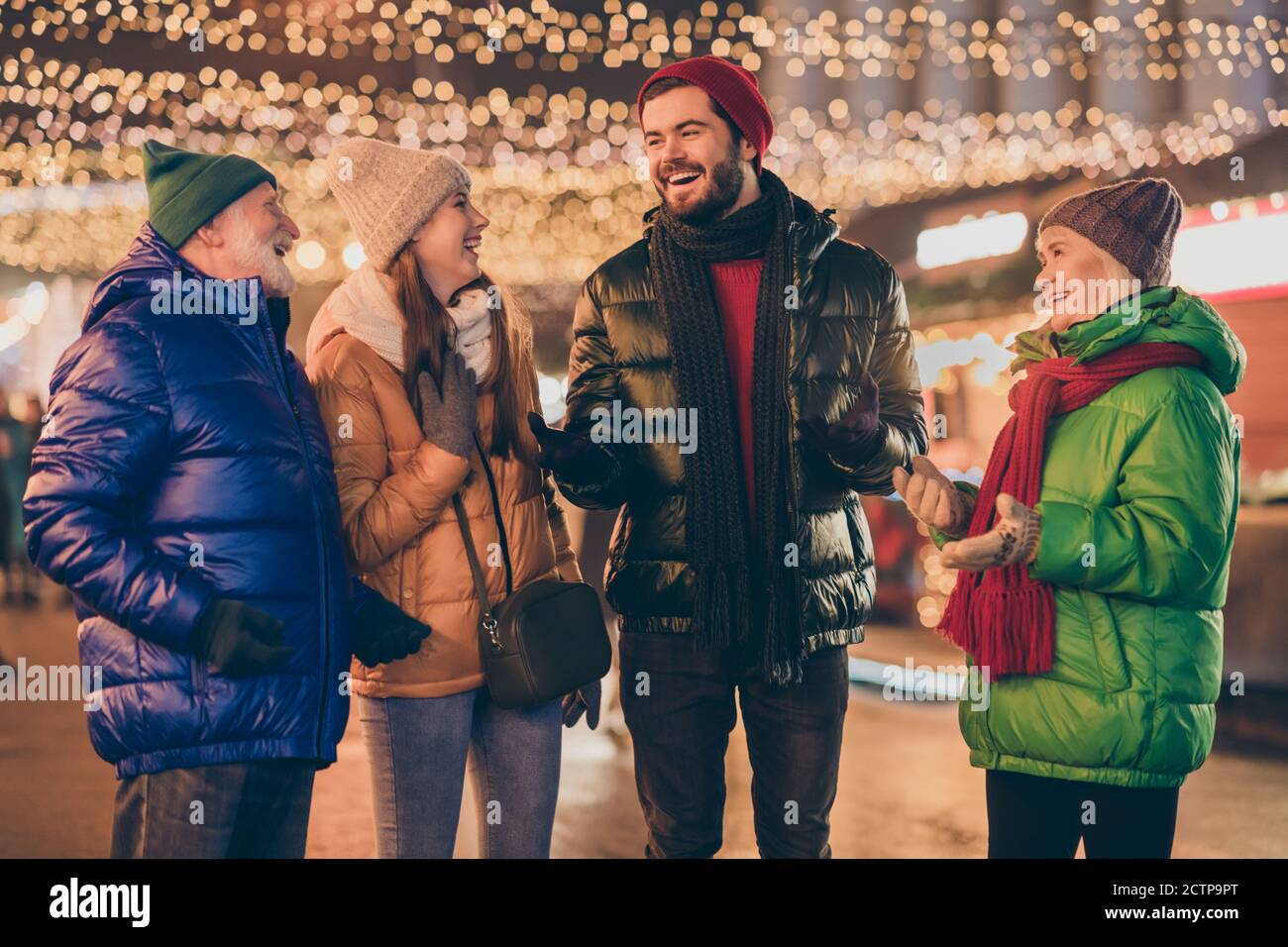 Photo of full family four members x-mas meeting chatting laughing grandpa tell joke wear outerwear hat scarf coat gloves multi-generation night street Stock Photo
