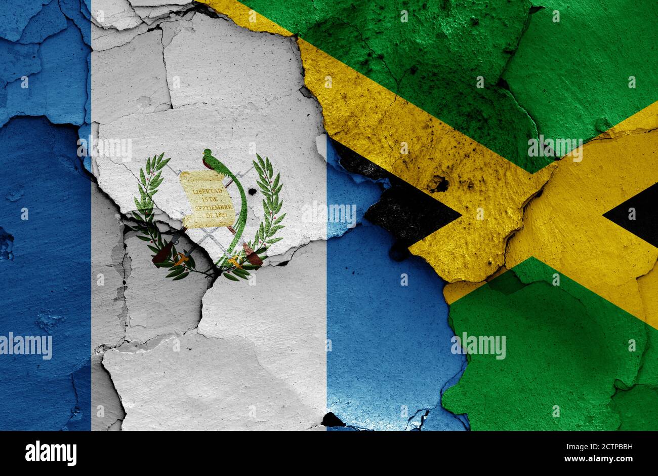 flags of Guatemala and Jamaica painted on cracked wall Stock Photo