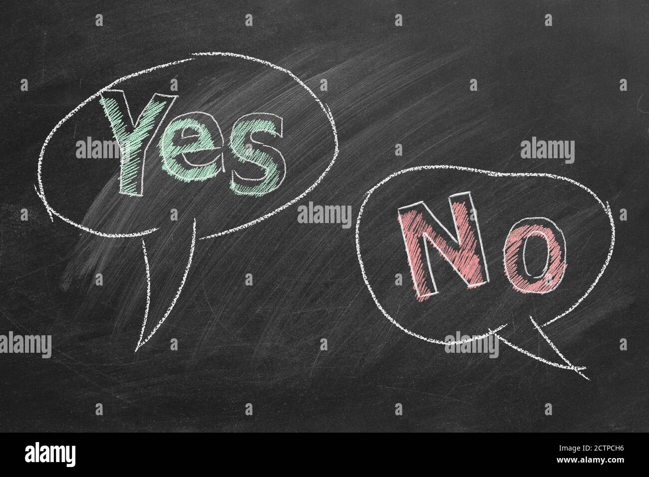 Speech bubbles with yes and no text written in chalk on a blackboard. Different points of view. Stock Photo