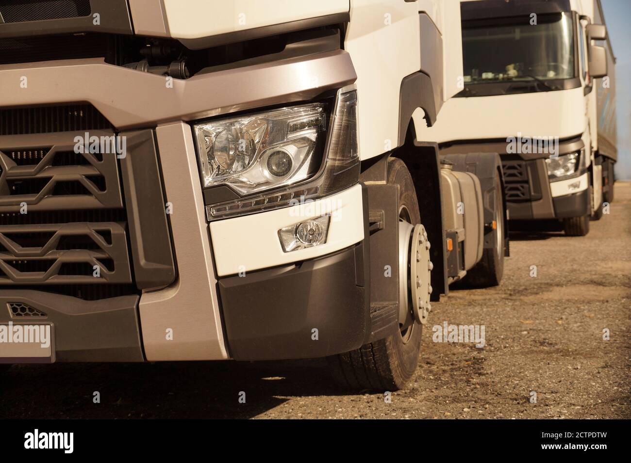 ront view of 18 wheeled trucks in the background of the second truck. Stock Photo