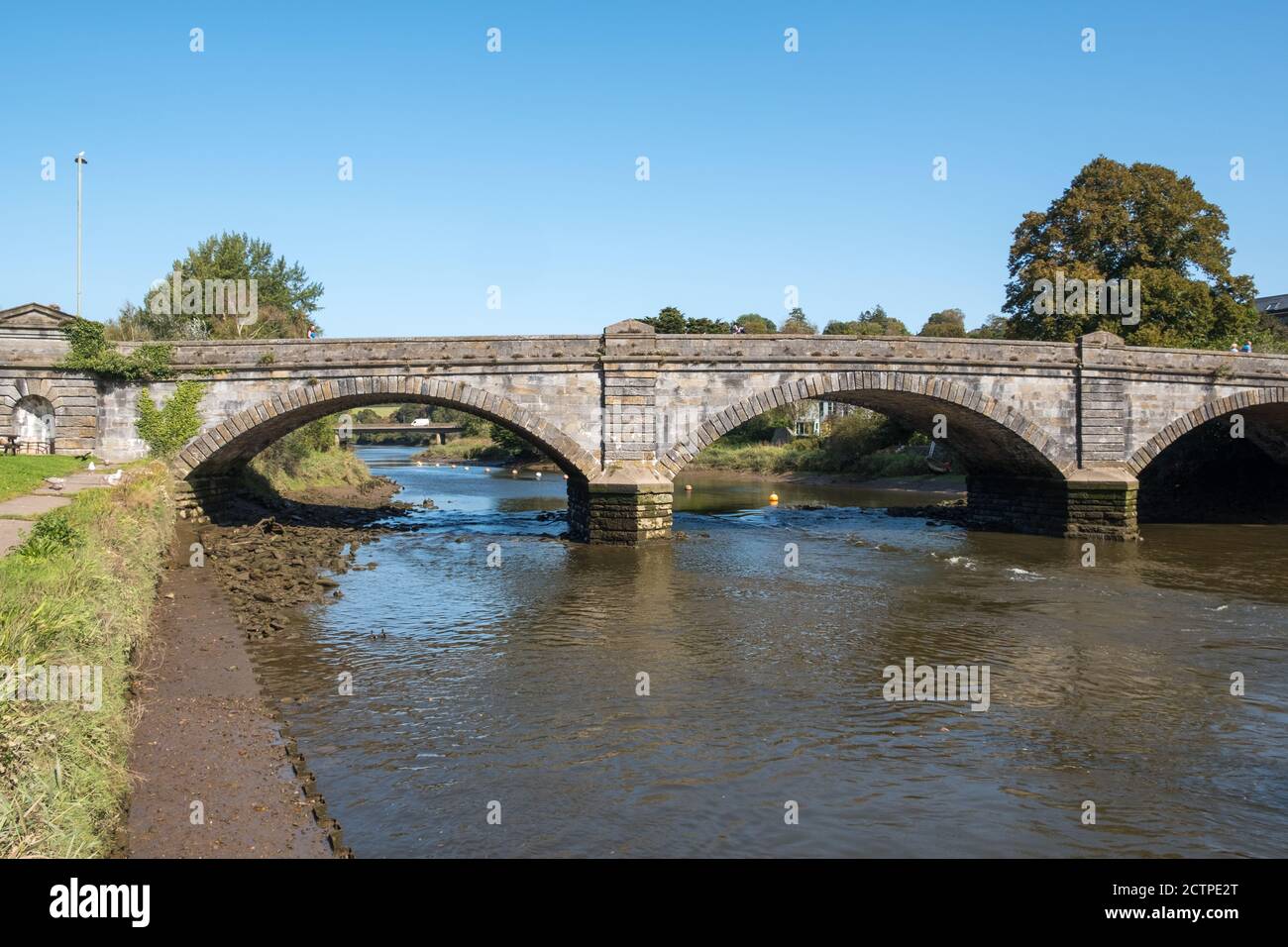 Old stone bridge crossing the River Dart at Bridgetown in the historic