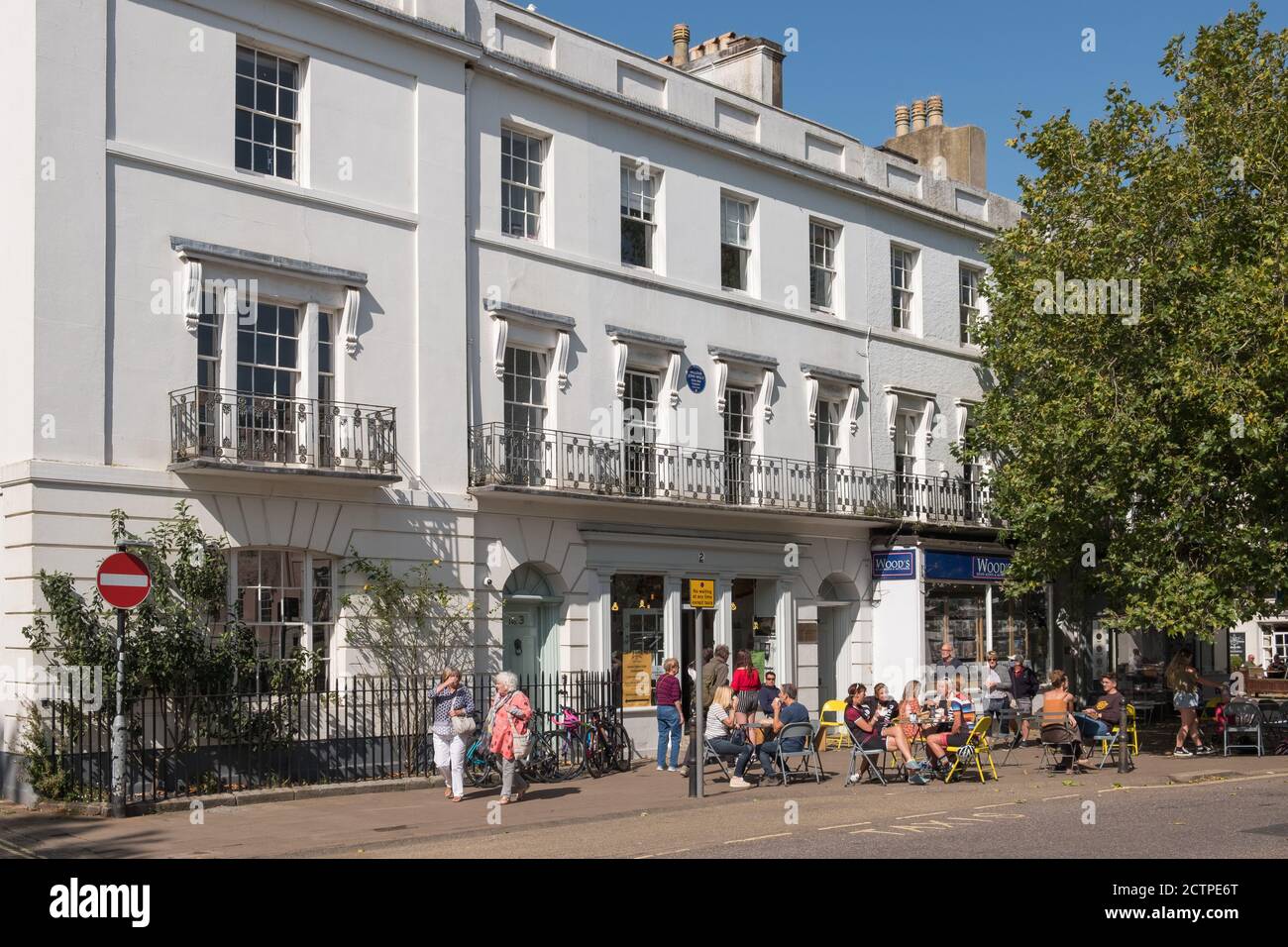 People sitting outside a cafe in the sunshine in The Plains in the historic market town of Totnes in the South Hams, Devon,UK Stock Photo