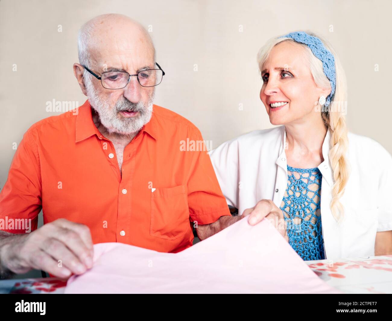 Horizontal portrait of a female medical assistant taking care of an ederly man Stock Photo