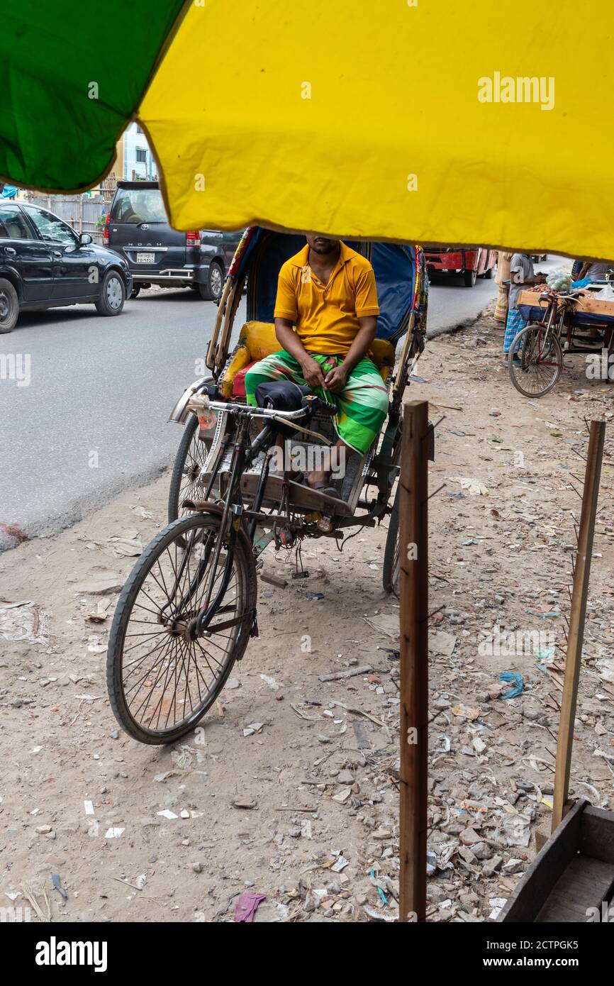 A rickshaw puller doing hard job under hot summer sun shine. I captured this image from Dhaka, Bangladesh. Stock Photo