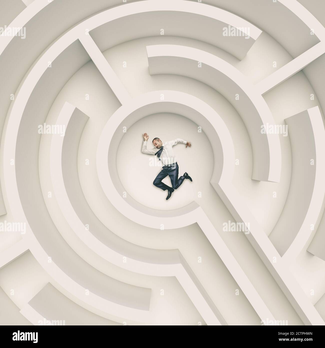 businessman passed out on the ground in the middle of a maze. concept of difficulty and challenge. Stock Photo