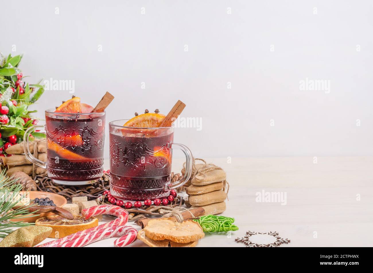Mulled wine in mugs with Christmas decor on a white wooden background with copy space. Stock Photo