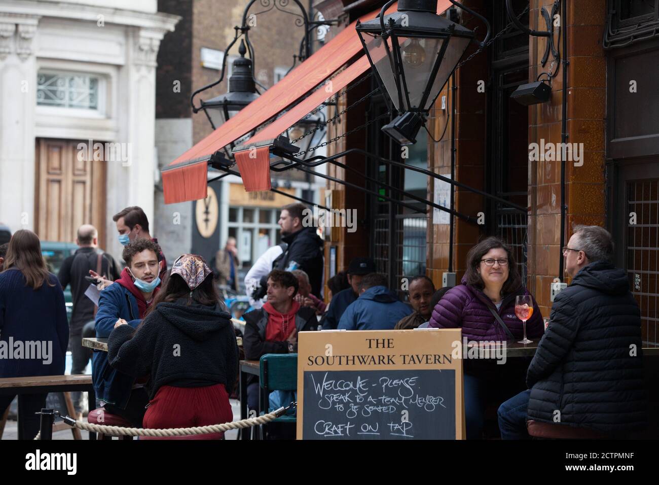 London. UK weather, 24 Sept 2020: Customers outside pubs in London's Borough Market take advantage of a dry spell before more rain is forecast. New coronavirus regulations limit social groups to six under the Rule of Six, and from today staff in restaurants, pubs and cafes must wear face masks. Anna Watson/Alamy Live News Stock Photo