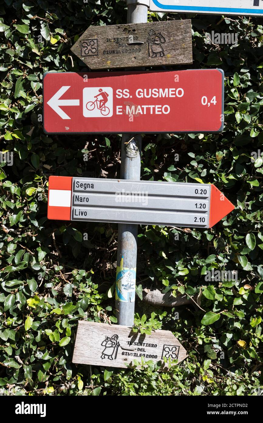 Various footpath and cycling signposts metal and wooden including a wooden sign for the 'il sentiero del giubileo 2000', Gravedona, Lombardy, Italy. Stock Photo